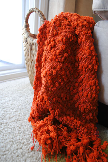 rust colored blanket in basket